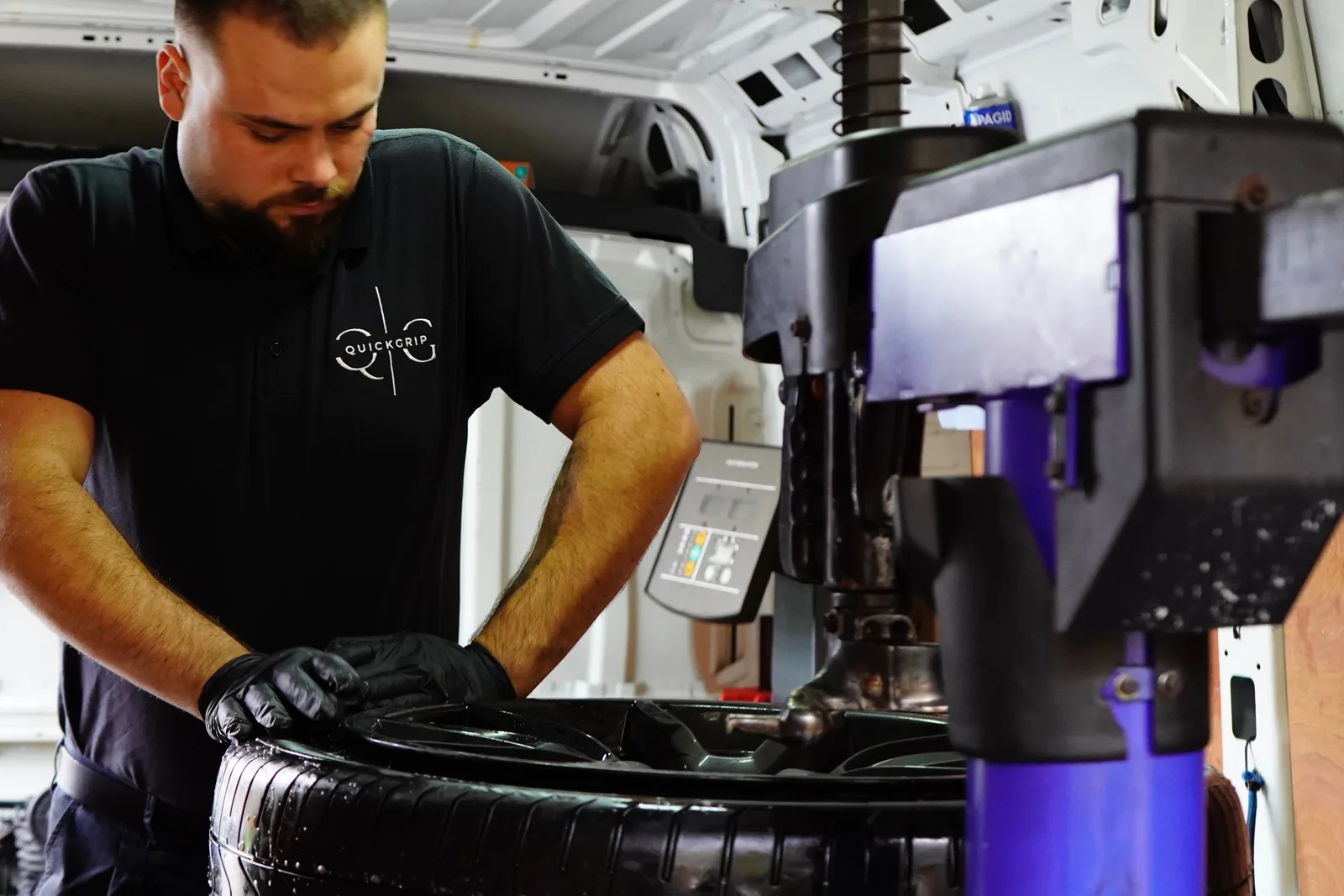 QuickGrip technician inspecting and repairing a punctured tyre in the van