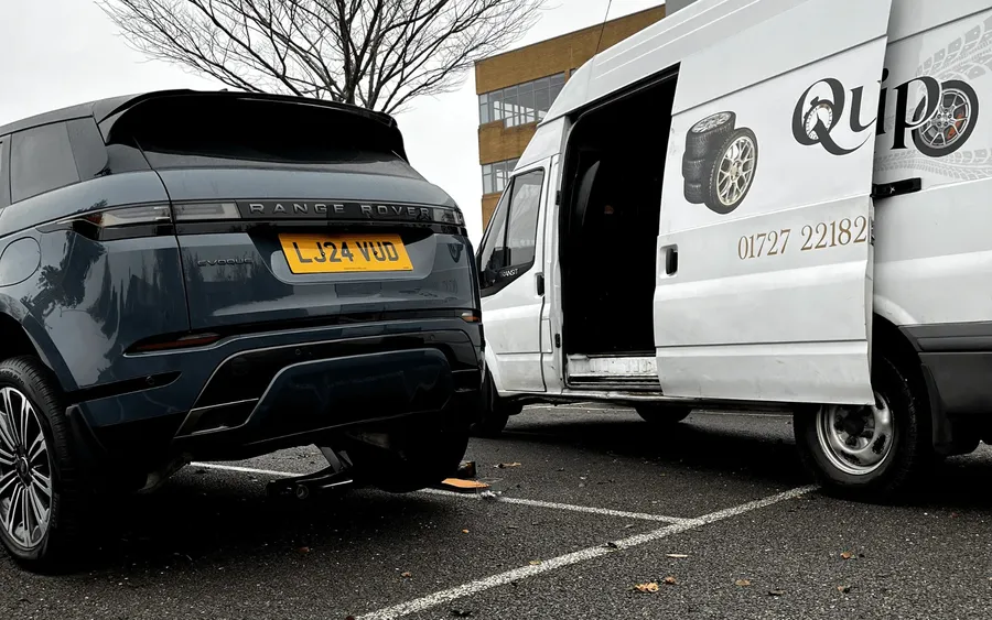 Range Rover beside a QuickGrip van mid puncture repair