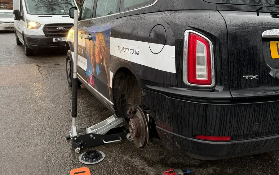 London-style taxi rear wheel removed and being repaired by QuickGrip